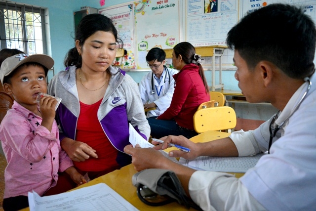 Bác sĩ Bệnh viện Đa khoa huyện Krông Năng kê đơn khám bệnh, hướng dẫn người dân sử dụng thuốc. 