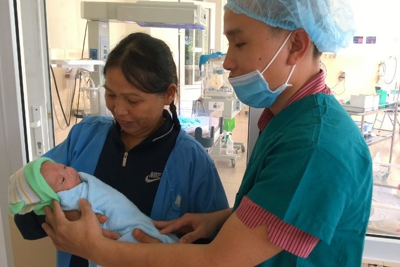 Bác sĩ Hoàng Minh Ngọc giao bé trai khỏe mạnh cho người thân trước giờ xuất viện.