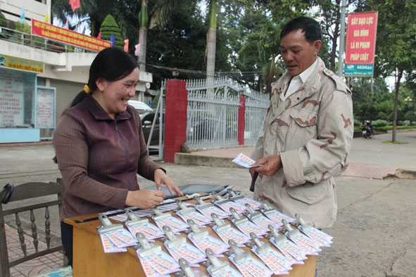 Khách mua vé số  truyền thống tại một điểm bán lẻ trên đường Đinh Tiên Hoàng, TP. Buôn Ma Thuột.