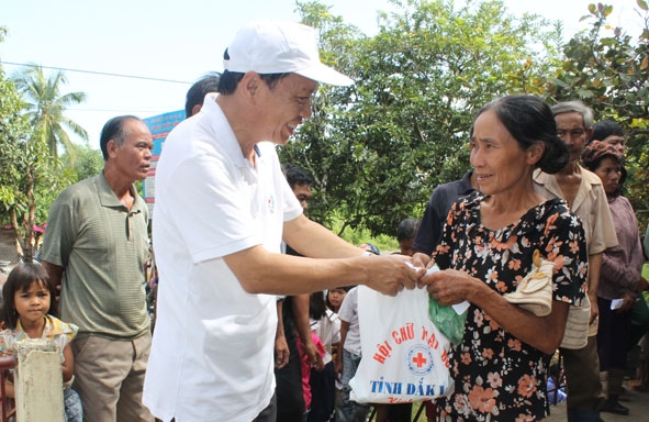 Ủy viên Ban Thường vụ Trung ương  Hội Chữ thập đỏ Việt Nam Lê Xuân Hồng tặng quà cho người dân buôn Đrang Phốk, xã Krông Na, huyện Buôn Đôn. 