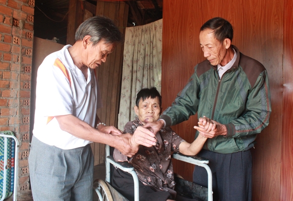 Ông Nguyễn Ước (bìa phải) hướng dẫn cách chăm sóc, tập vật lý trị liệu cho bà Hồng 