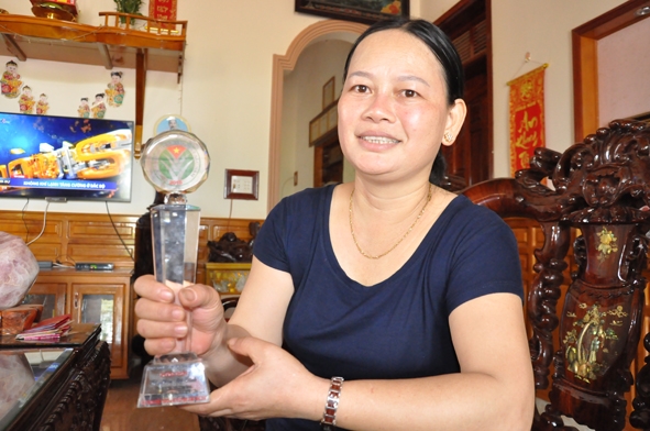Chị Hòa Thị Dinh với chiếc cúp lưu niệm “Nông dân Việt Nam xuất sắc năm 2016” 