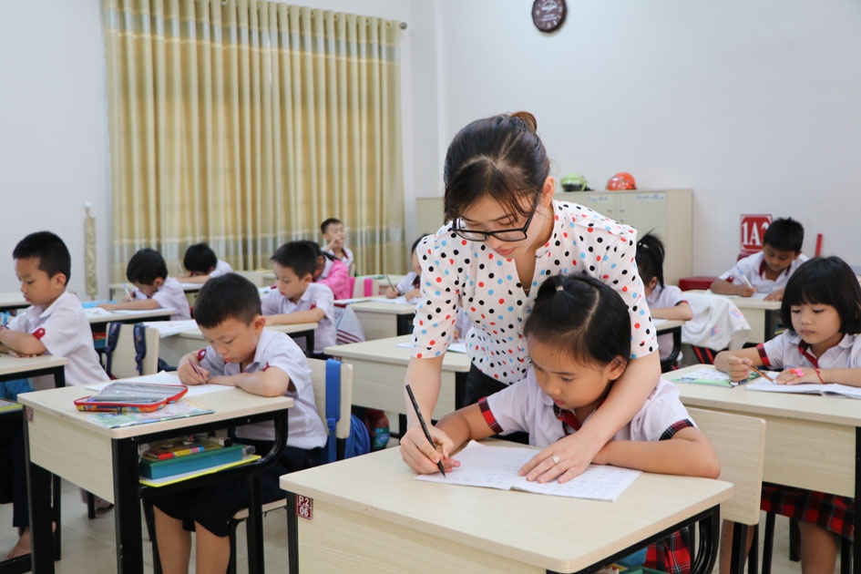 Giáo viên Trường Hoàng Việt hướng dẫn học sinh lớp 1 rèn chữ viết.