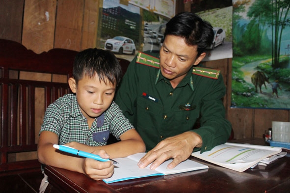 Trung úy Lê Minh Hùng hướng dẫn em Phạm Văn Duy học bài.