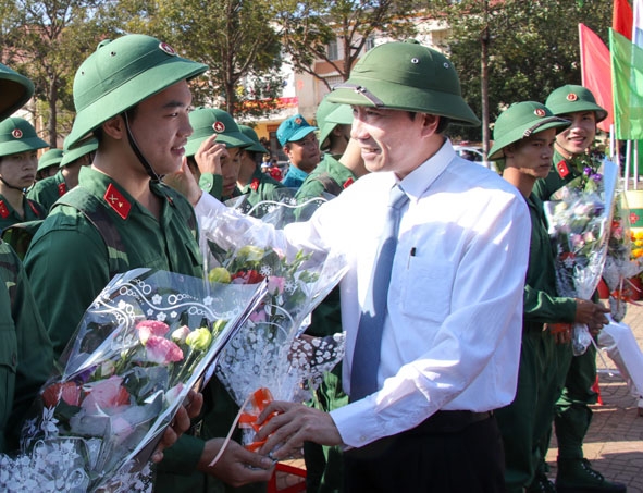Bí thư Tỉnh ủy Êban Y Phu (ảnh trái) và Chủ tịch UBND tỉnh Phạm Ngọc Nghị (ảnh phải)  tặng hoa động viên thanh niên TP. Buôn Ma Thuột lên đường nhập ngũ năm 2017. Ảnh: H.Gia