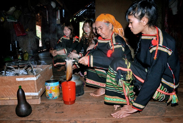 Bà H’Lum Adrơng (ở buôn Sut Mgrư, xã Cư Suê, huyện Cư M’gar) hướng dẫn con cháu cách rang cà phê truyền thống. 