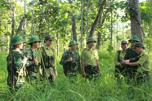 Cán bộ, chiến sĩ hai lực lượng kiểm lâm và biên phòng trao đổi, nắm tình hình trên đoạn đường tuần tra. 