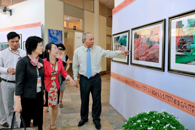 Nguyên Phó Chủ tịch Thường trực UBND tỉnh Y Dhăm ÊNuôl giới thiệu với bạn bè quốc tế một số hình ảnh Lễ hội Cà phê Buôn Ma Thuột.