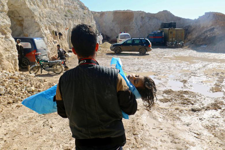 Người đàn ông bế thi thể của một em bé sau một vụ tấn công được cho là bằng khí độc ở thị trấn Khan Sheikhoun nằm trong khu vực phiến quân kiểm soát hôm 4/4.