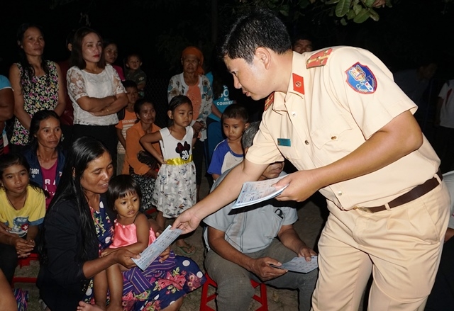 Đội CSGT (Công an huyện) phát tờ rơi tuyên truyền cho bà con tại buôn Ja, xã Ea Trul.