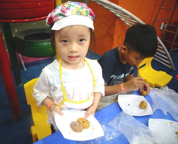 Các em nhỏ vui chơi, thử tài làm bánh tại một quán cà phê trên đường Nguyễn Công Trứ.   
