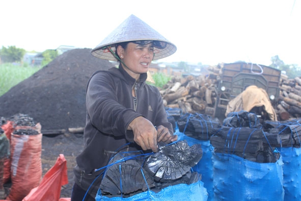 Chị Trần Thị Bích Hằng đóng than vào bao để bán cho thương lái.   
