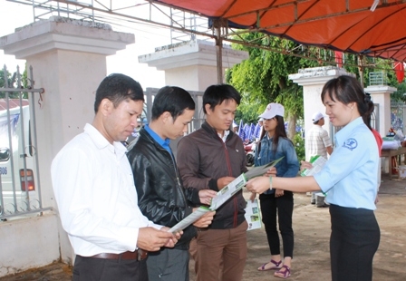 Cán bộ Trung tâm Truyền thông giáo dục sức khỏe tỉnh phát tờ rơi tuyên truyền về tác hại của thuốc lá đến người dân huyện Cư Kuin.