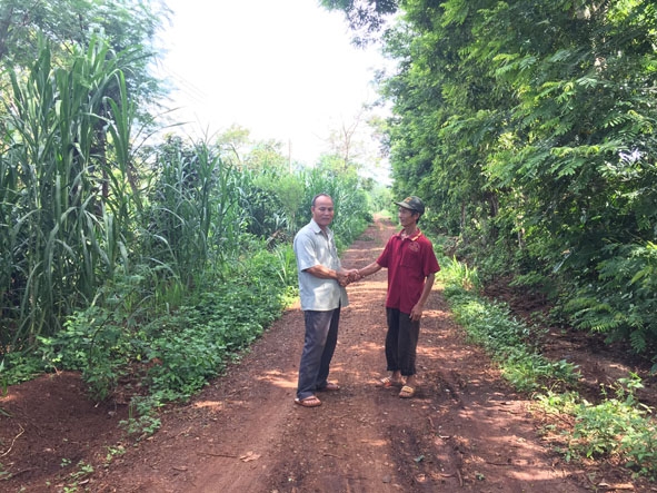 Ông Phan Văn Sửu (phải) trên tuyến đường trước nhà.