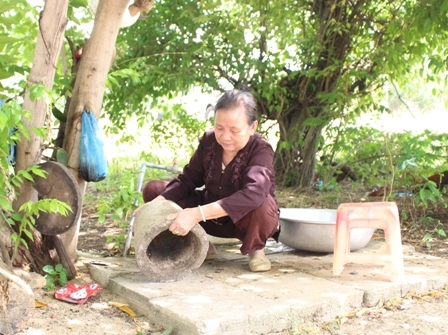 Người dân thị trấn M'Đrắk, huyện M'Đrắk thay rửa dụng cụ chứa nước nhằm loại bỏ nơi muỗi đẻ trứng. 