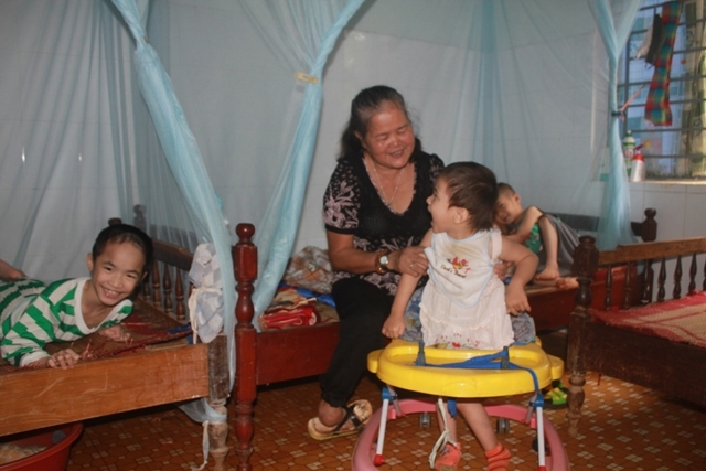 Bà Lê Thị Chắt đang chăm sóc các trẻ em khuyết tật tại Trung tâm Bảo trợ xã hội tỉnh. 
