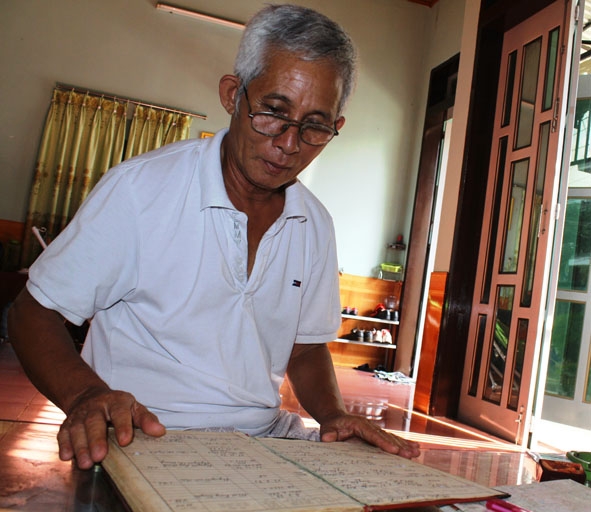 Ông Nguyễn Ngọc Sương lần giở cuốn sổ lưu giữ thông tin các liệt sỹ.  