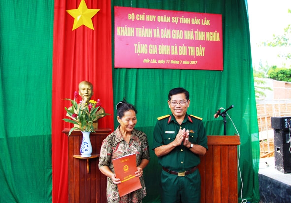  Đại tá  Niê Brét,  Phó Chủ nhiệm Chính trị,  Bộ CHQS tỉnh trao  Quyết định  bàn giao nhà cho bà  Bùi Thị Đây. 