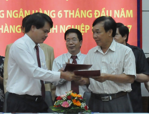 Giám đốc Agribank Đắk Lắk Vương Hồng Lĩnh (bên trái) trao thỏa thuận cấp tín dụng cho một doanh nghiệp xuất khẩu cà phê trên địa bàn tỉnh. 
