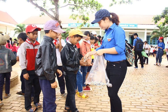 Thành viên Đội CTXH tỉnh phát quà  cho thiếu nhi buôn Ê Căm, thị trấn  Buôn Trấp, huyện  Krông Ana. 