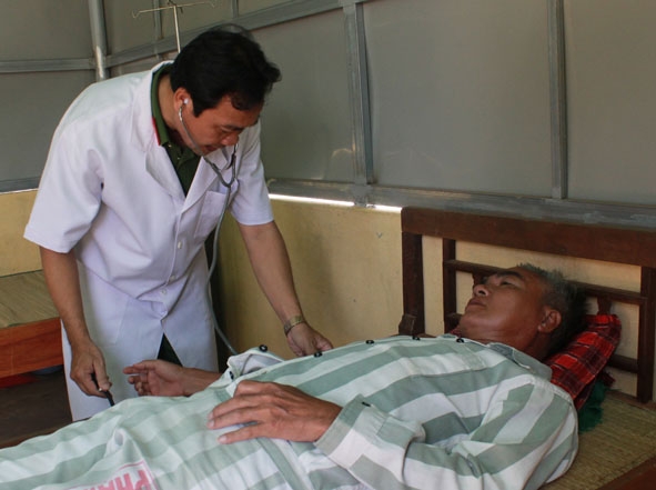 Trung tá, bác sĩ Cao Huy Vui kiểm tra sức khỏe cho một phạm nhân bị tăng huyết áp. 