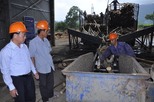 Chủ tịch UBND huyện M'Đrắk Hòa Quang Khiêm (bìa trái) thăm Nhà máy băm dăm mảnh, Chi nhánh HTX Tiến Nam.  Ảnh:  N. Hoa
