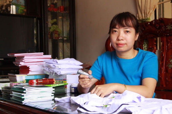 Cô Hương tự tay vẽ logo lên từng chiếc áo trắng  cho học sinh.  