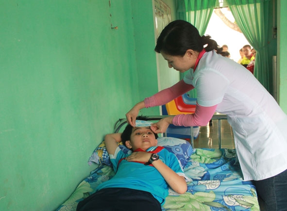 Nhân viên y tế học đường của Trường Tiểu học Nguyễn Viết Xuân (xã Ea Toh, huyện Krông Năng) chăm sóc sức khỏe ban đầu cho học sinh.