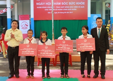 Giám đốc Quỹ Bảo trợ trẻ em tỉnh Lâm Đình Nhiên và đại diện Công ty Bảo hiểm nhân thọ AIA trao hợp đồng bảo hiểm Vì tương lai cho các học sinh nghèo vượt khó. 
