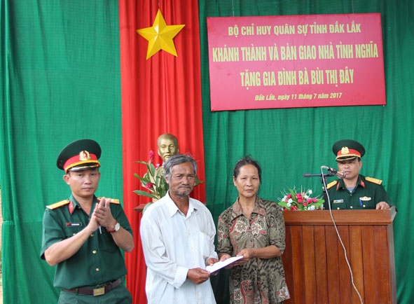 Thượng tá  Lê Xuân Chung,  Phó Bí thư Đảng ủy,  Chính trị viên Ban CHQS huyện Ea Kar trao số tiền  hỗ trợ xây nhà  cho gia đình  bà Bùi Thị Đây.     