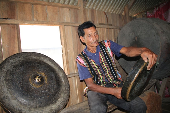 Già Y Ninh Êban ở buôn Lê, thị trấn Liên Sơn đang kiểm tra lại âm thanh của từng chiếc chiêng.