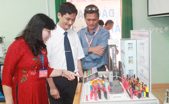 Thầy Trần Văn Dũng (đứng giữa) đại diện nhóm tác giả giới thiệu về mô hình “Hệ thống đỗ xe tự động  dùng PLC S7-200”.   