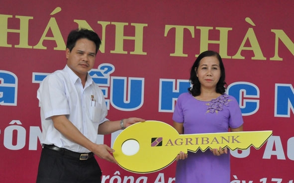 Giám đốc Agribank Đắk Lắk Vương Hồng Lĩnh trao chìa khóa tượng trưng cho lãnh đạo Trường Tiểu học Nguyễn Viết Xuân. 