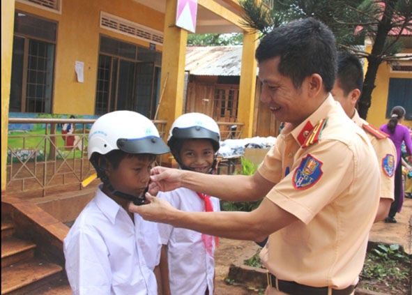 Cảnh sát giao thông - Công an huyện Cư M’gar tặng mũ bảo hiểm cho học sinh Trường Tiểu học  Lê Thị Hồng Gấm (xã Cư Suê). 