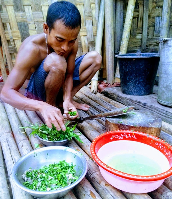 Thanh niên Ma Coong ở bản Nịu, xã Thượng Trạch,  huyện Bố Trạch (Quảng Bình) đang chế biến món láp. 