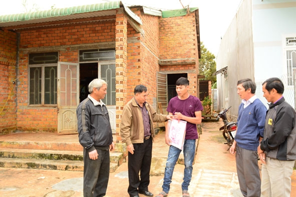 Anh Phan Văn Hân (giữa) nhận tiền hỗ trợ  từ Quỹ  cứu trợ của Ủy ban MTTQ  Việt Nam tỉnh.    