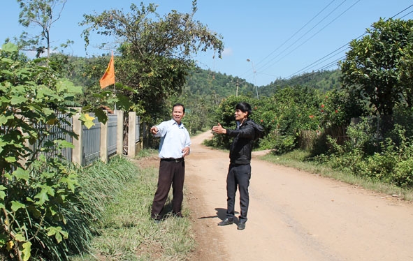Ông Y Dhăm Bdap, Bí thư Chi bộ buôn Kpung, xã Hòa Hiệp, huyện Cư Kuin (bìa trái) nói về việc người dân  hiến đất làm đường. 
