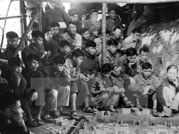 Các chiến sĩ phân đội 1 và 2 quân Giải phóng Trị-Thiên-Huế nghiên cứu sa bàn trước khi tấn công trung đoàn 7 thiết giáp ngụy.  Ảnh: Nguyễn Hồng Sáu/TTXGP