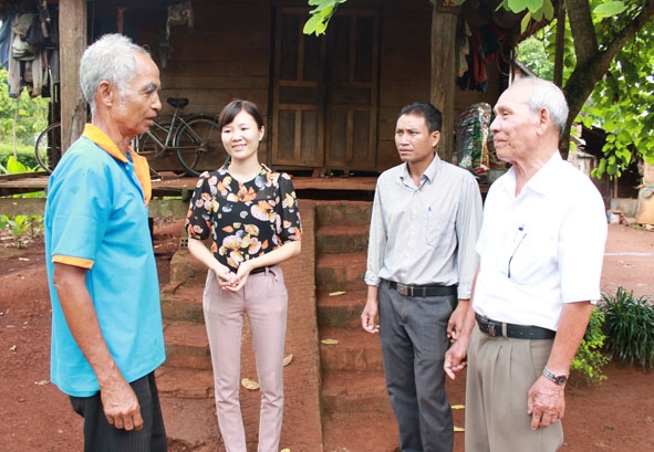 Già làng Y Jút BKrông (bìa phải) gặp gỡ, trò chuyện với người dân trong buôn. 