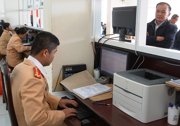 Ông Nguyễn Hoàng Việt ở phường Tân An (TP. Buôn Ma Thuột) đang thực hiện thủ tục bấm biển số xe ô tô tại bộ phận một cửa, Phòng Cảnh sát giao thông (Công an tỉnh).
