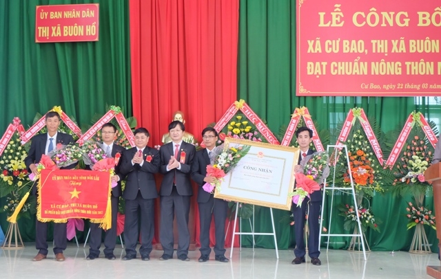 Đồng chí Phạm Minh Tấn, Phó Bí thư Thường trực Tỉnh uỷ (người thứ 3 từ trái qua) trao Bằng công nhận và cờ thi đua của UBND tỉnh tặng chính quyền và nhân dân xã Cư Bao. 
