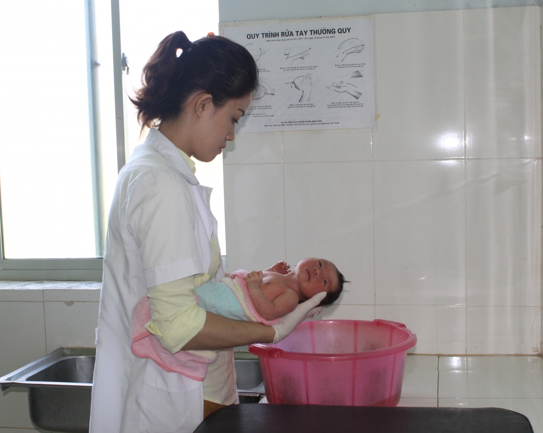 Nữ hộ sinh Trạm Y tế xã Hòa Xuân (TP. Buôn Ma Thuột) tắm cho trẻ sơ sinh. 