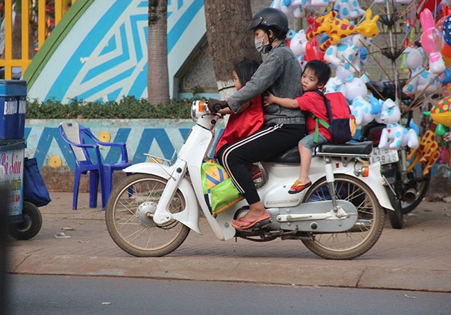 Hình ảnh  phụ huynh  chở trẻ nhỏ không  đội mũ  bảo hiểm, không thắt  đai an toàn rất phổ biến trên đường phố. 
