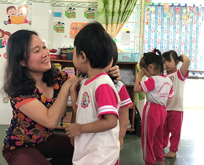 Cô Lê Thị Dung, Hiệu trưởng Trường Mầm non Tân Lợi đang trò chuyện với trẻ. 
