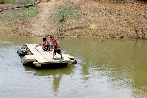 Trẻ em  thôn Ea Rớt qua suối bằng bè. 