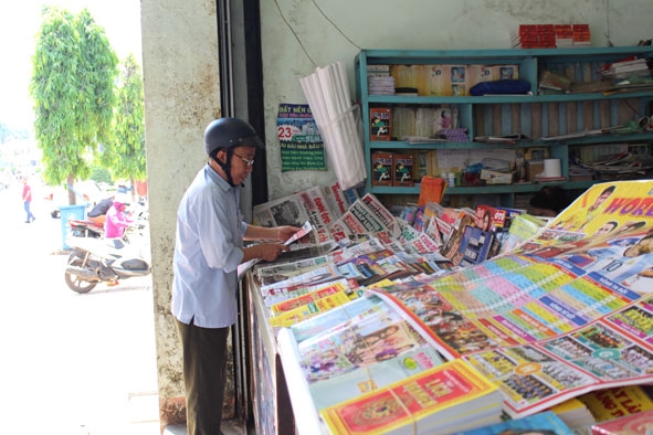 Khách mua báo giấy tại sạp báo Thái Sơn . 