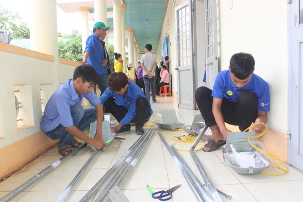 Đoàn viên, thanh niên các đơn vị chuẩn bị hệ thống điện để thực hiện công trình  “Thắp sáng đường quê”. 