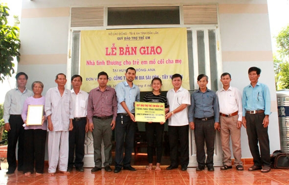 Đại diện các nhà tài trợ và chính quyền địa phương bàn giao nhà Tình thương cho anh em Nguyễn Thị Anh Vân ở buôn Ea Na (xã Ea Na, huyện Krông Ana). 