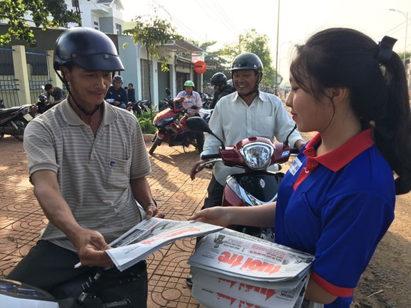 Các tình nguyện viên huyện Krông Pắc bán báo gây quỹ “Tiếp sức mùa thi”. 