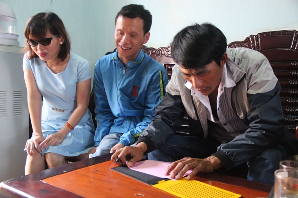 Chị Nguyễn Thị Hương – Chủ tịch Hội Người mù huyện Krông Búk ôn tập chữ nổi cho 2 hội viên. 